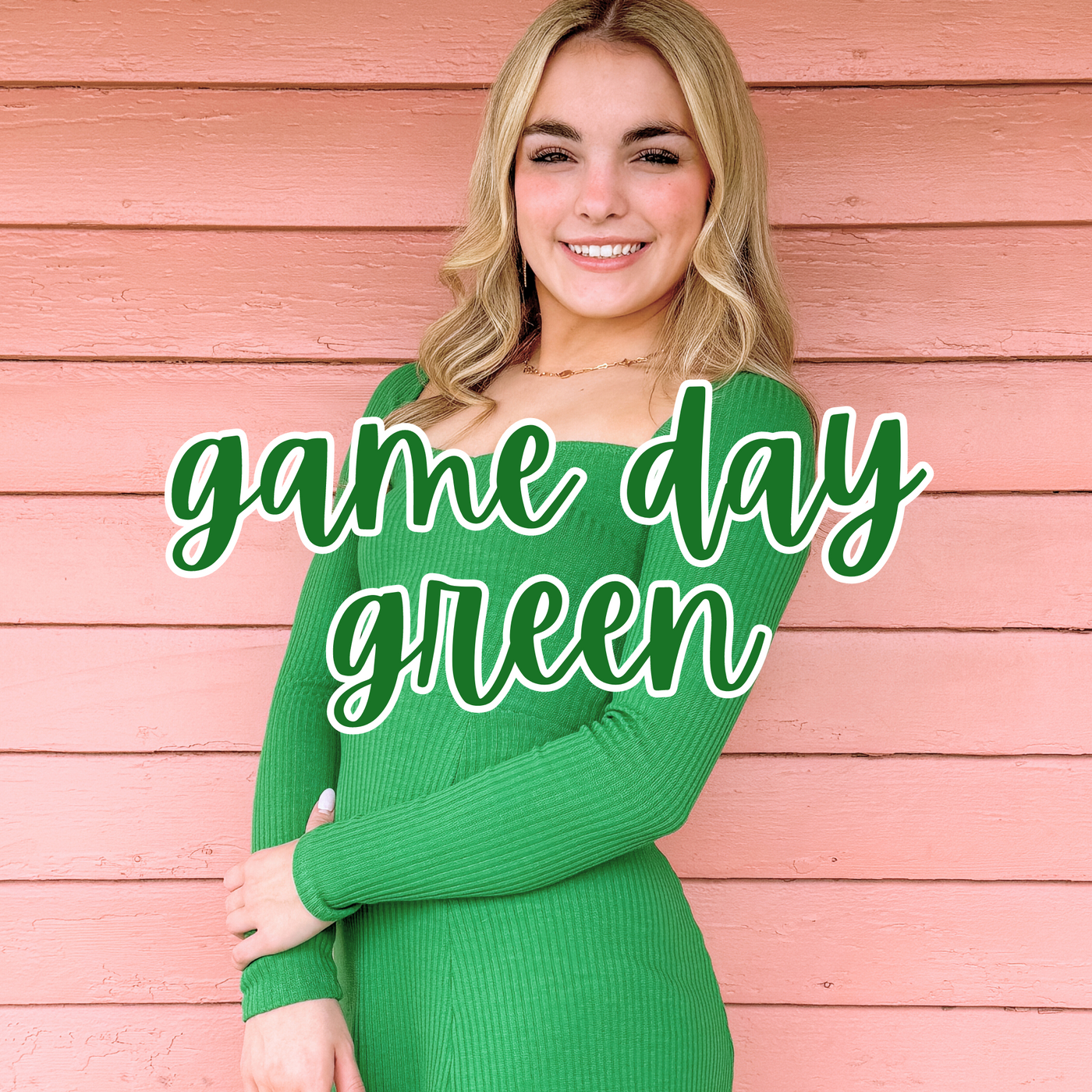 A smiling blonde woman poses against a pink wooden wall, wearing a fitted long-sleeve green dress. "Game Day Green" is overlaid in bold green script, highlighting a stylish and spirited outfit perfect for supporting your team.