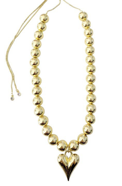 Gold beaded necklace with a heart pendant on a white background