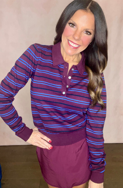 Woman wearing a maroon and blue striped long-sleeve shirt with a matching skirt against a beige background